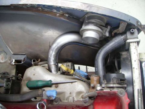 1969 MINI Cooper - Custom intercooler piping and turbocharger installed in an engine bay, with a green screwdriver resting on the engine block.