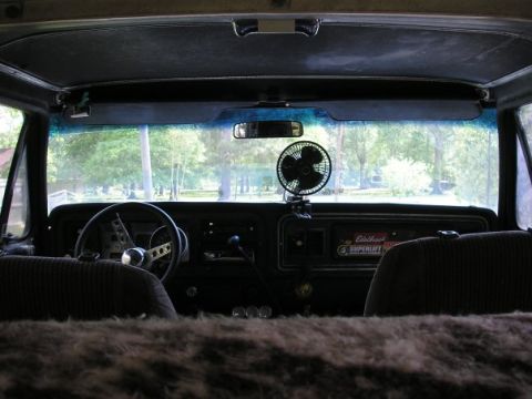 1979 Ford Bronco - The interior of a vehicle is shown, a dashboard with a fan and a steering wheel.