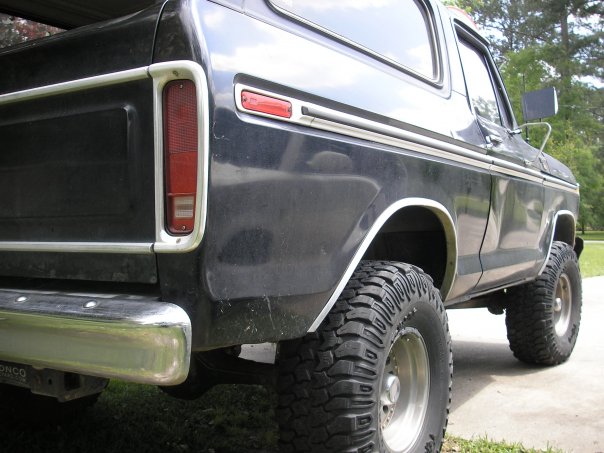 Black 1978 Ford Bronco rear quarter panel with chrome trim and large tires