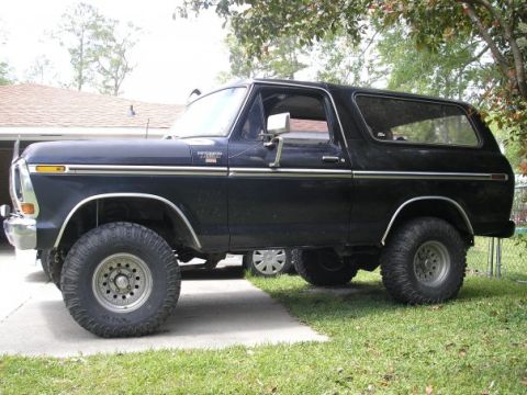 1979 Ford Bronco - Side view of a black Ford Bronco with chrome accents and off-road tires.