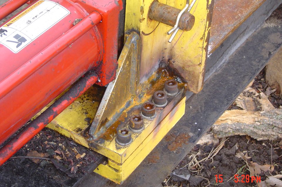 Yellow log splitter wedge with red hydraulic cylinder and metal inserts