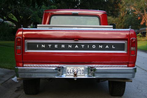 1975 International Scout II - Rear view of a red International pickup truck a prominent tailgate badge and a Texas Farm Truck license plate.