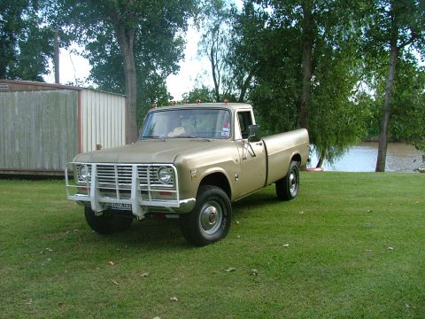 1975 International Scout II - This 1975 International Scout II pickup truck is parked on a grassy area next to a lake.