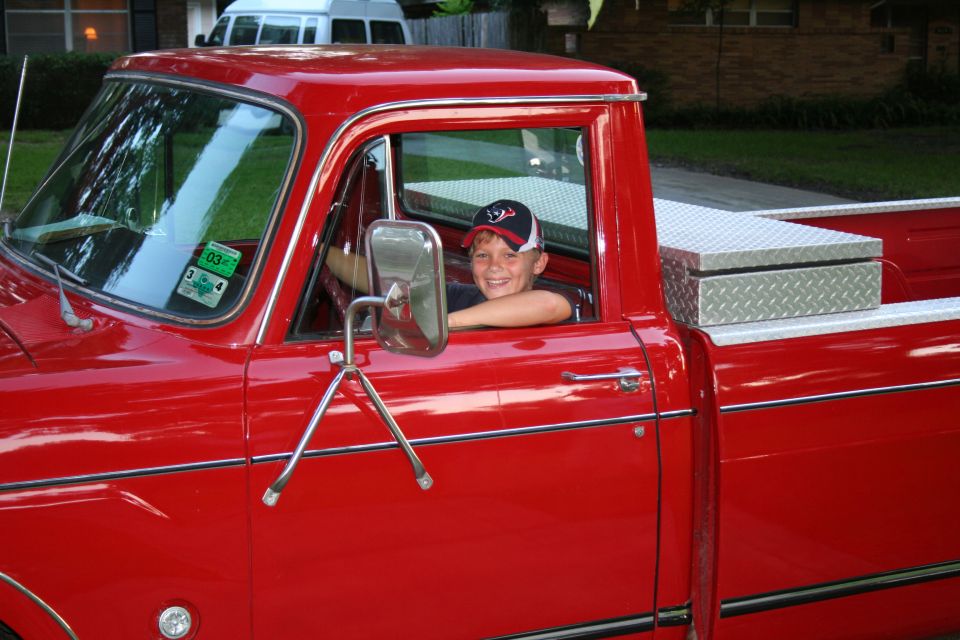 Boy in red pickup truck, diamond plate toolbox in bed