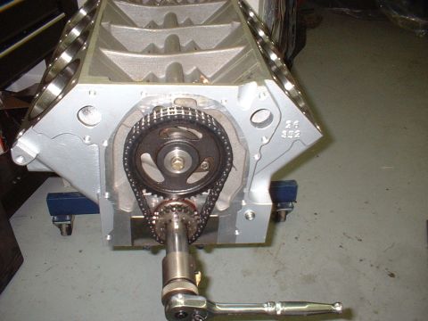 1969 Mercury Cyclone - Close-up of an engine block's timing chain and gears, with a tool attached.