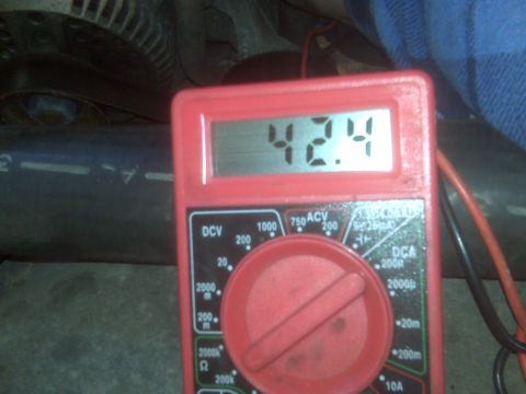 1995 Ford Bronco - A red digital multimeter displays a reading of 42.4 volts, connected to what appears to be an engine bay. The multimeter has various settin…