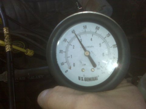 1995 Ford Bronco - A U.S. GENERAL pressure gauge is held in a hand, with the needle pointing to approximately 5 bar. The gauge is connected to a black hose wi…