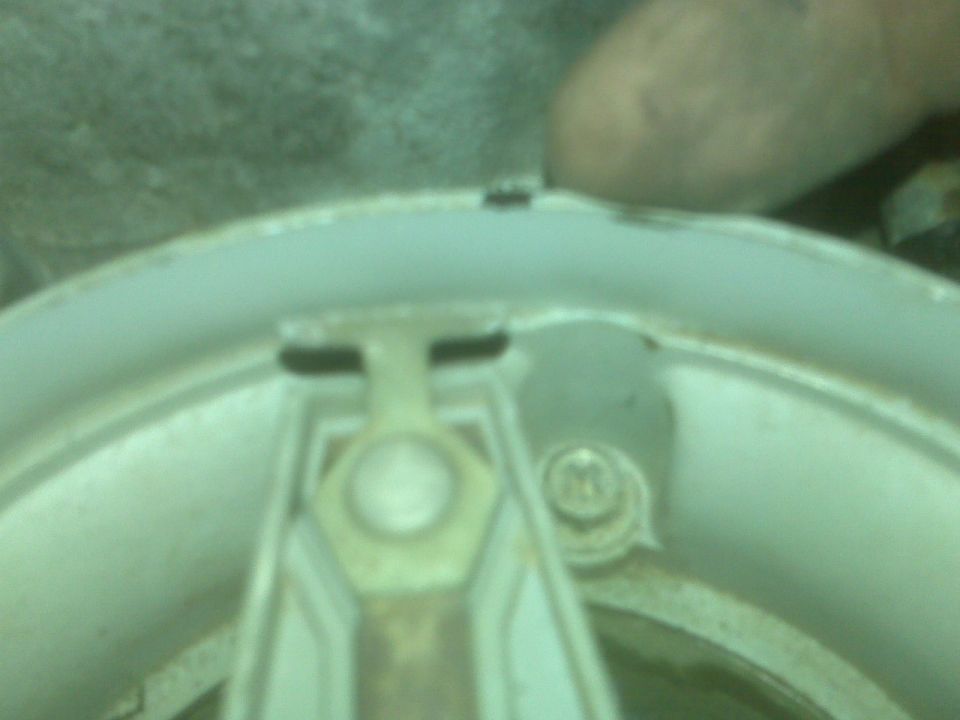 Distributor cap interior with rotor arm and a thumb visible