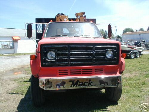 Red medium-duty Chevrolet truck front view with black grille and Mack bumper plate