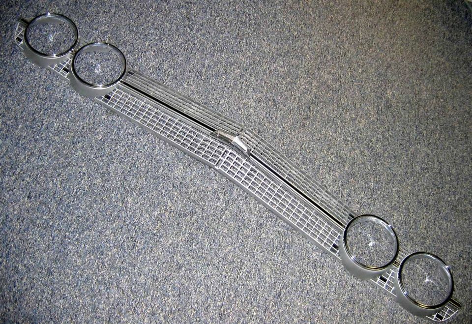 Car grille with four headlight bezels on gray carpet
