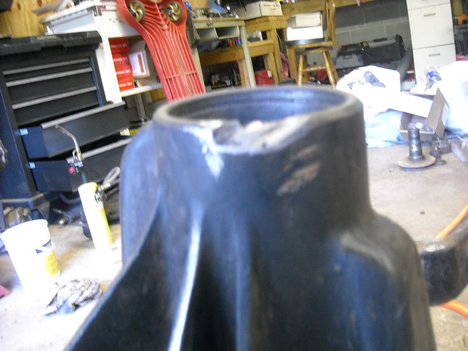 Close-up of a black painted axle housing end on a shop bench