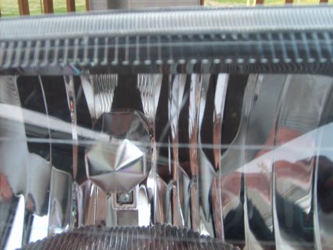 1993 Ford Crown Victoria - Close-up of the clear, faceted lens of a headlight assembly. The internal reflector and bulb housing are visible behind the lens.