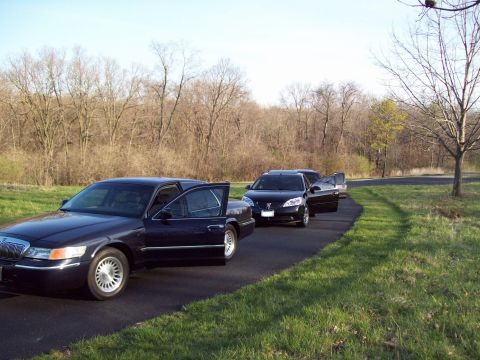 1999 Mercury Grand Marquis - A dark blue Mercury Grand Marquis is parked on the side of a road with its driver's side doors open. Another black sedan is parked behind i…