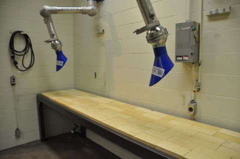 1996 Ford Bronco - Photograph of two articulated fume-extraction arms above a wood-topped workbench.