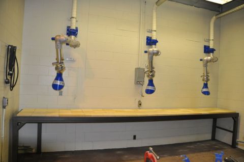 1996 Ford Bronco - Photograph of three blue articulated fume-extraction arms above a long workbench.