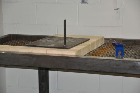 1996 Ford Bronco - Photograph of a steel welding bench with firebrick, mesh, and a vertical plate fixture.