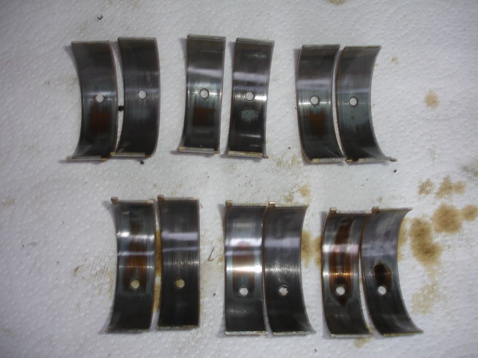 Photo of six pairs of engine bearing shells laid out on a rag