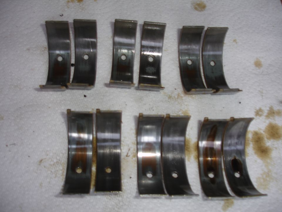 Photo of six pairs of engine bearing shells arranged on cloth