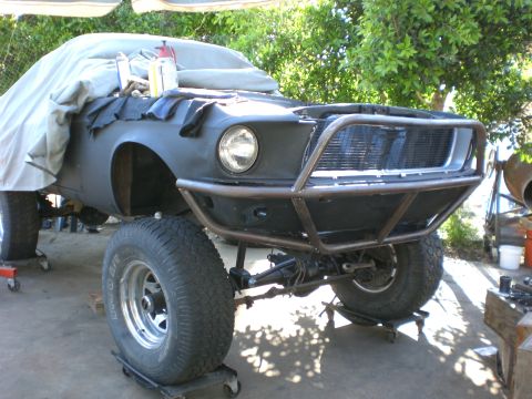 1967 Ford Mustang - A modified 1967 Ford Mustang, nicknamed "monster", is shown with a custom roll cage and large off-road tires. The front of the vehicle is c…