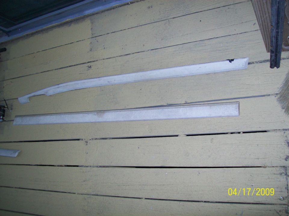 Two automotive trim pieces on a wooden deck.