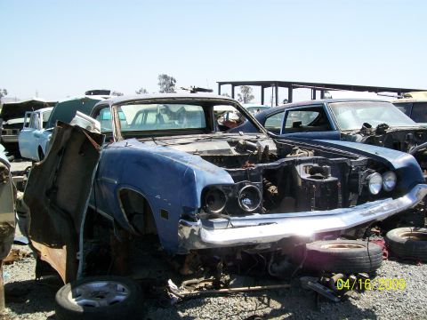 1972 Ford Ranchero - Junkyard scene with a 1972 Ford Ranchero in the foreground, other vehicles visible.