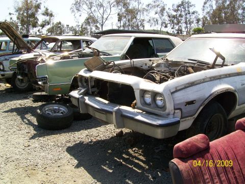 1972 Ford Ranchero - Junkyard scene with multiple vehicles, some with hoods open and missing parts.