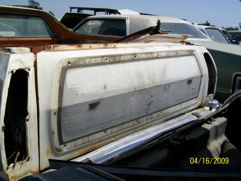 1972 Ford Ranchero - Junkyard scene with a pickup truck tailgate as the main focus, other vehicles in background.