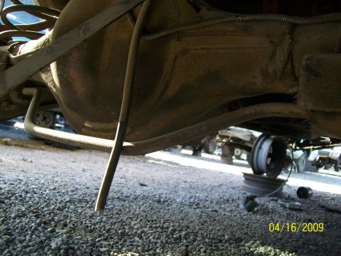 1972 Ford Ranchero - Junkyard scene showing vehicle undercarriage parts and other vehicles in the background.