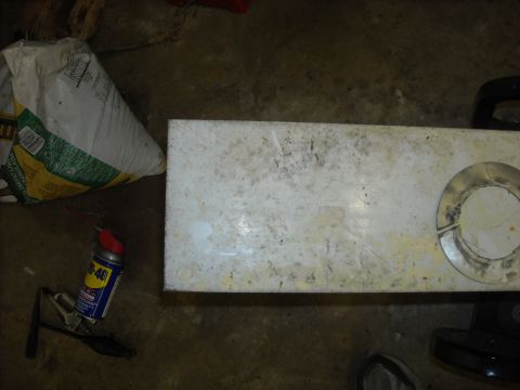 1979 Ford F-150 - A white panel with a circular cutout is visible next to a bag of material and a can of WD-40.