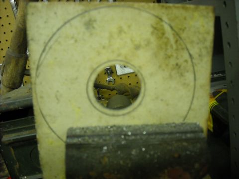 1979 Ford F-150 - A template with a circular outline and a central hole is held in a vise, with tools visible in the background.