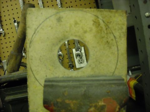 1979 Ford F-150 - A part with a circular cutout reveals tools and an electrical outlet mounted on a pegboard in the background.