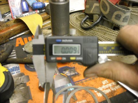 1979 Ford F-150 - A digital caliper measures a small metal part, with various tools and a yellow tape measure visible in the background.