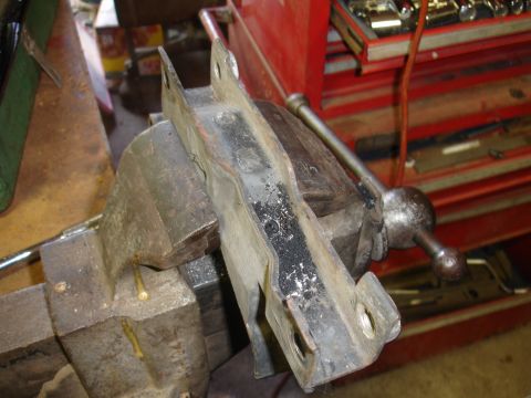 1995 Ford Taurus - A metal bracket is secured in a vise, ready for work. A red toolbox is visible in the background.