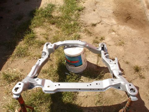 1995 Ford Taurus - Painted subframe assembly on sawhorses, with a bucket in the background.