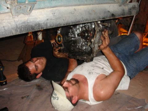 1995 Ford Taurus - Mechanics are shown working on the engine of a vehicle, likely during a repair or removal process.
