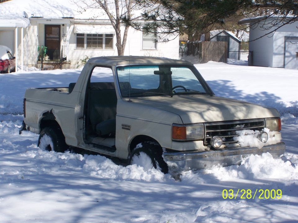 1991 Ford Bronco stuck in deep snow, driver's door open