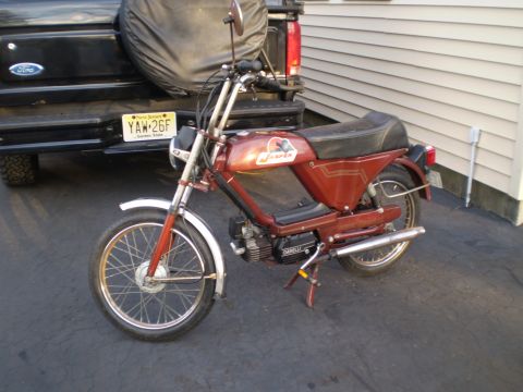 1981 Garelli Rally Sport - A red moped with chrome fenders and exhaust is parked in front of a black Ford truck.