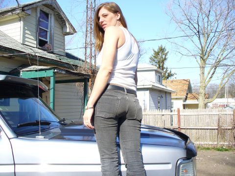 1994 Ford Bronco - A woman stands on the hood of a silver 1994 Ford Bronco in front of a house.