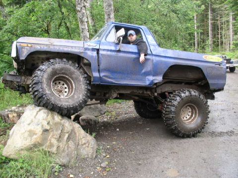 1979 Ford Bronco - Modified 1979 Ford Bronco navigating a rocky trail with a driver inside.