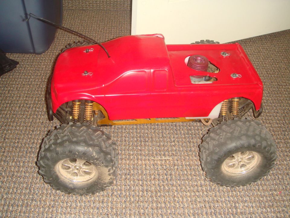 Red remote control monster truck with large tires and visible engine components