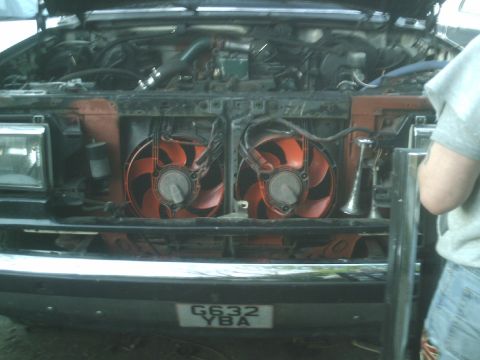 1989 Ford Bronco - The engine bay features dual orange fans and a visible license plate, but the vehicle year is not discernible from the image.