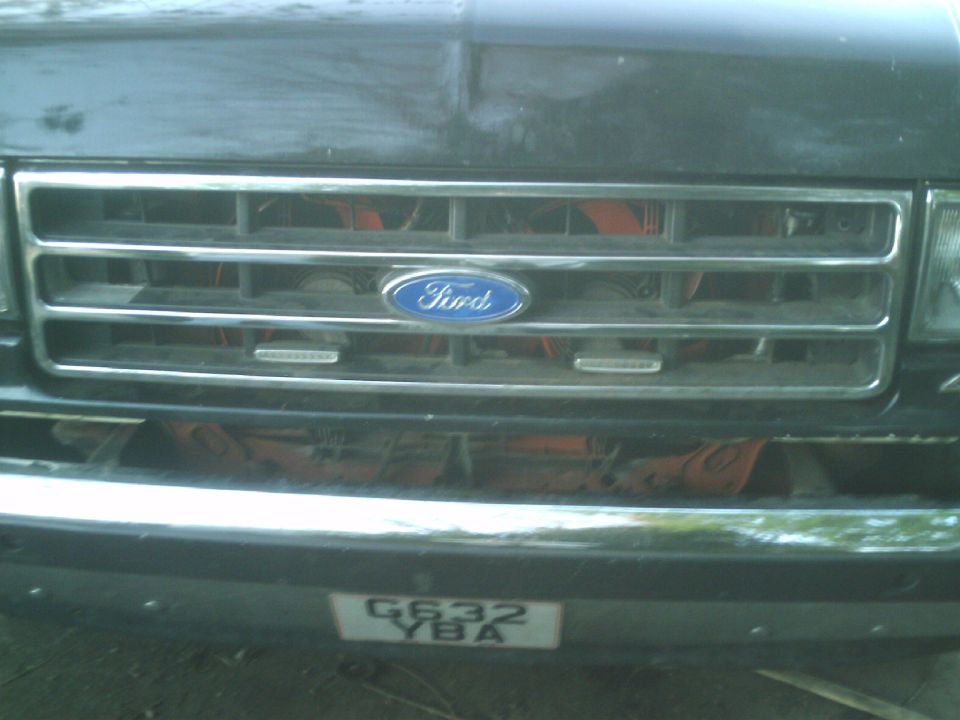 Front grille of a Ford truck with a blue Ford oval badge. License plate reads G632 YBA