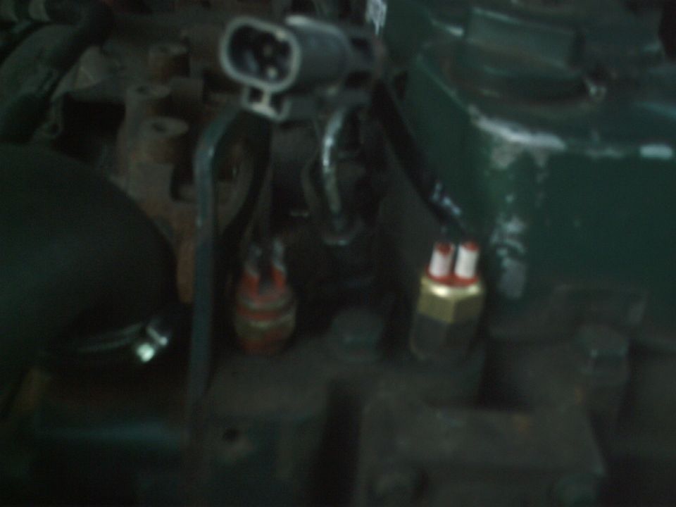 Close-up of engine components with electrical connectors and sensors