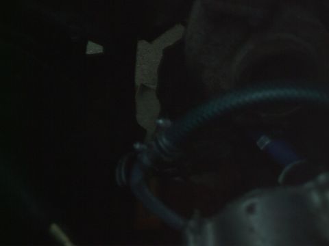 1989 Ford Bronco - A dark engine bay shows a blue hose with metal fittings.