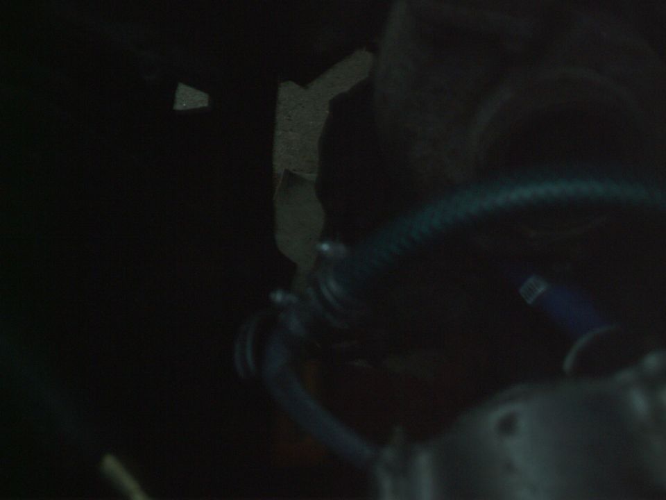 Close-up of a blue hose in a dark engine bay