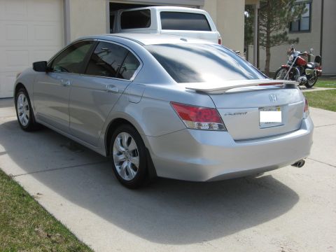 2009 Honda Accord - This silver 2009 Honda Accord sedan features a rear spoiler and is parked in a driveway.