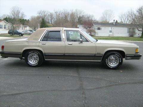 1988 Mercury Grand Marquis - This 1988 Mercury Grand Marquis sedan is shown from its side profile, a two-tone paint scheme and chrome wheels.