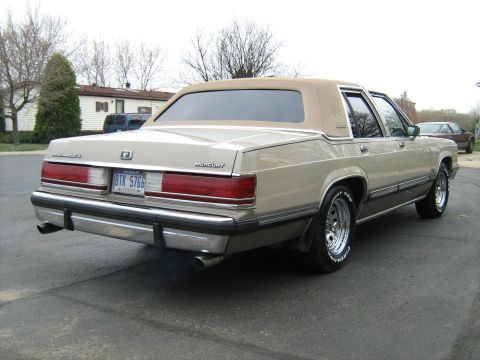 1988 Mercury Grand Marquis - This 1988 Mercury Grand Marquis features a two-tone paint scheme with a tan vinyl roof and a prominent chrome rear bumper.
