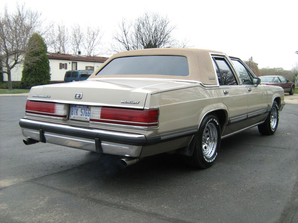 Tan 1988 Mercury Grand Marquis rear view with vinyl roof and chrome bumper