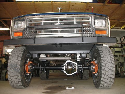 1985 Ford Bronco - This lifted Ford truck features a prominent bull bar and aggressive off-road tires, with its grille suggesting an early 1980s model year.